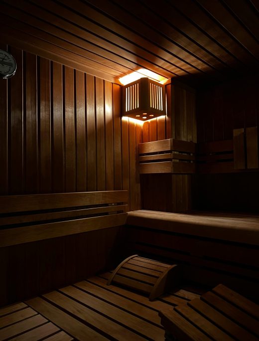 Inviting sauna room with wooden interiors and ambient lighting. Perfect for relaxation.
