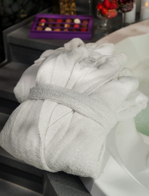 Elegant white bathrobe near a bubbling spa bath, perfect for relaxation and comfort.